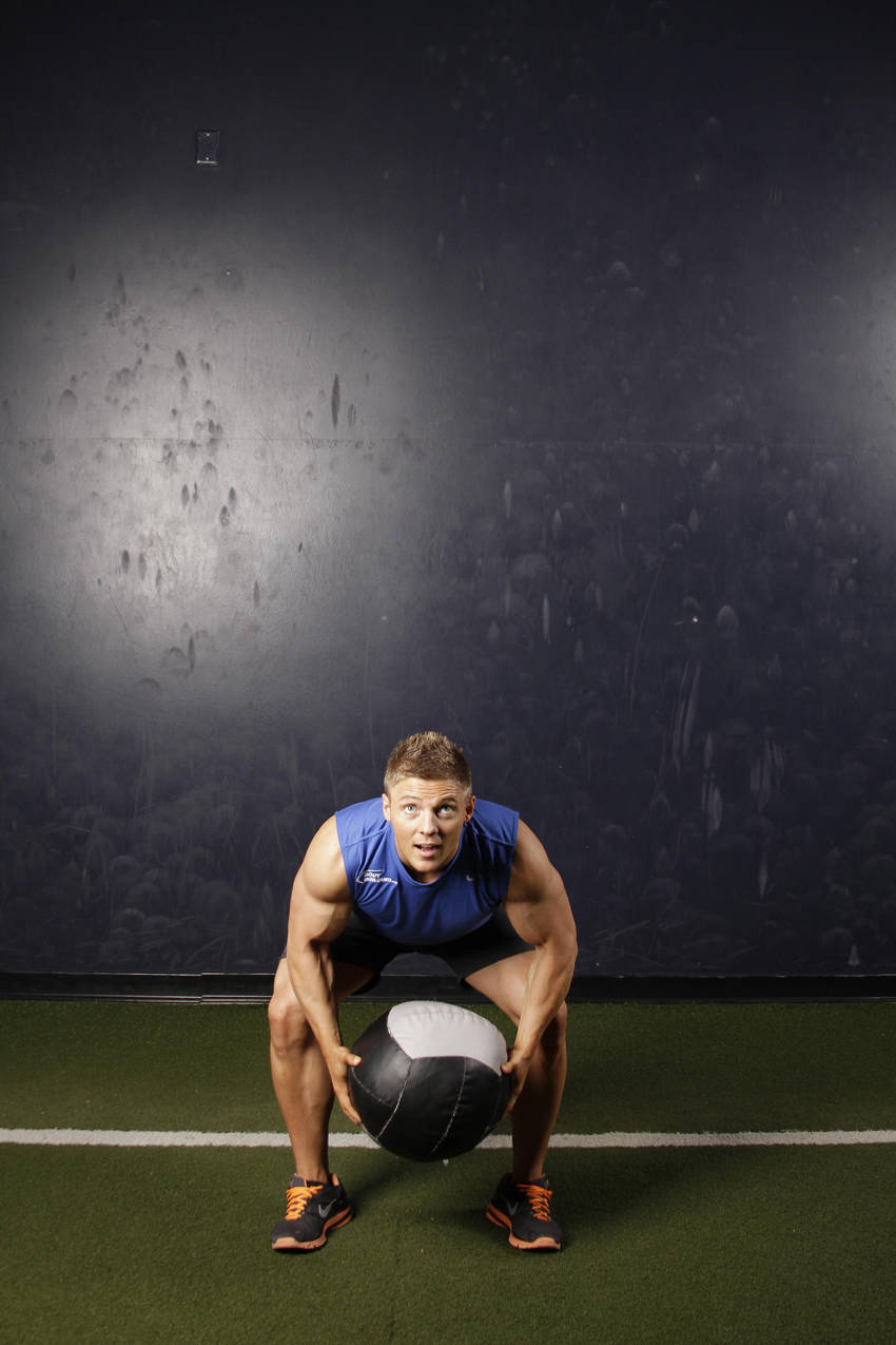 Demonstration of Backward Medicine Ball Throw exercise showing proper form and technique