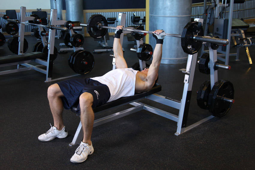 Demonstration of Barbell Guillotine Bench Press exercise showing proper form and technique