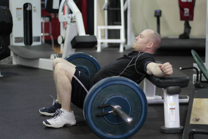 Demonstration of Barbell Hip Thrust exercise showing proper form and technique