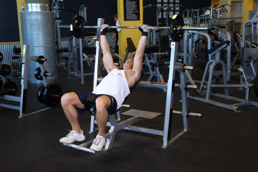 Demonstration of Barbell Incline Shoulder Raise exercise showing proper form and technique