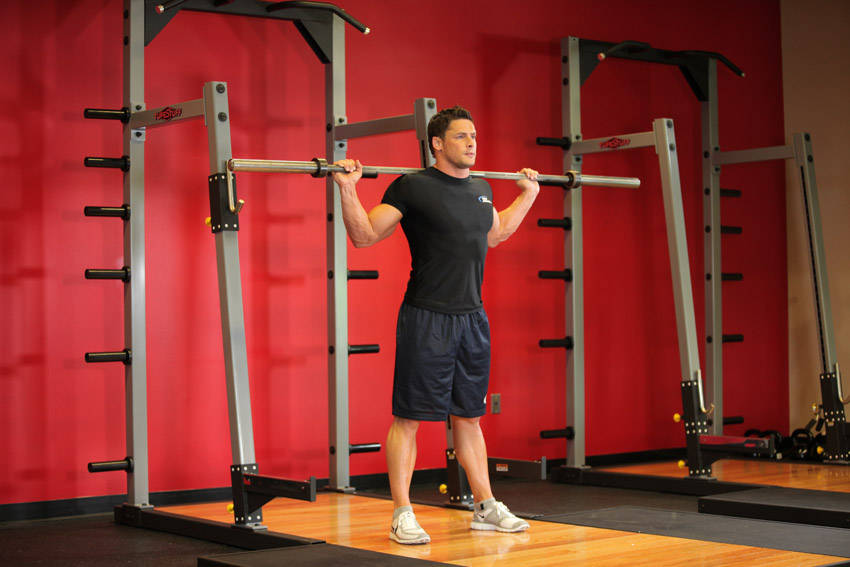 Demonstration of Barbell Side Bend exercise showing proper form and technique