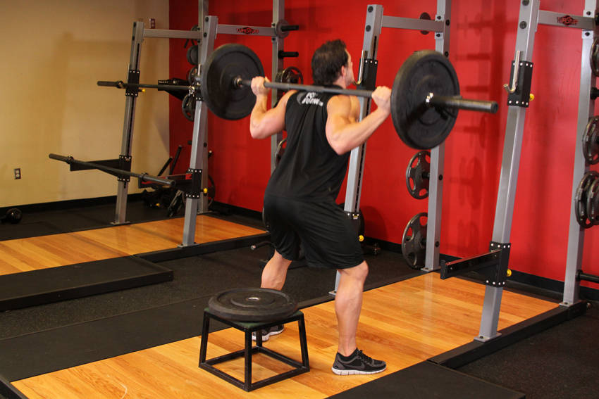 Demonstration of Barbell Squat To A Bench exercise showing proper form and technique