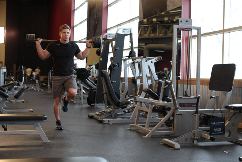 Demonstration of Barbell Walking Lunge exercise showing proper form and technique