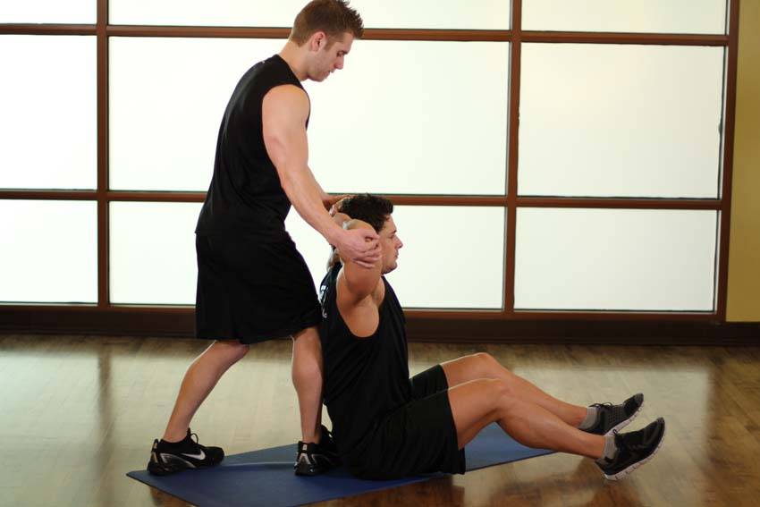 Demonstration of Behind Head Chest Stretch exercise showing proper form and technique