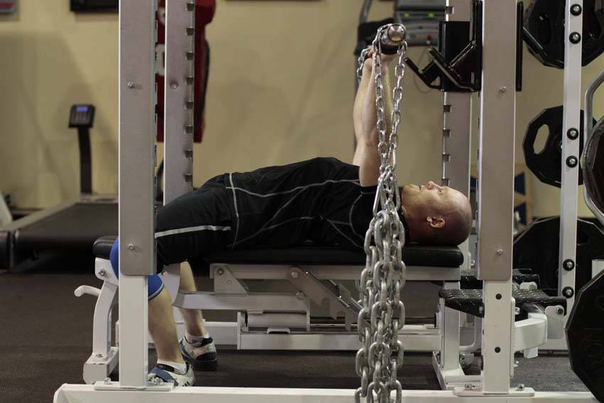 Demonstration of Bench Press with Chains exercise showing proper form and technique