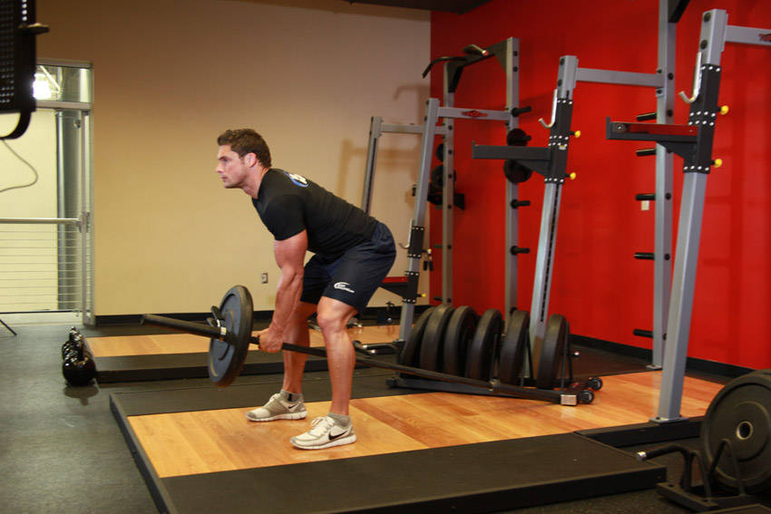 Demonstration of Bent Over One-Arm Long Bar Row exercise showing proper form and technique