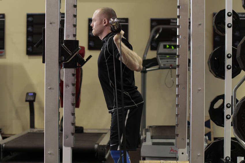 Demonstration of Box Squat with Bands exercise showing proper form and technique