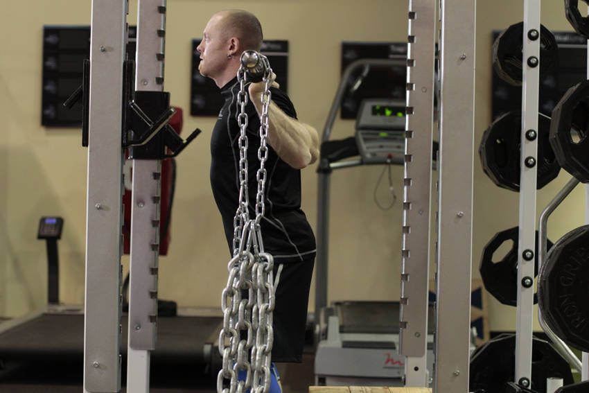 Demonstration of Box Squat with Chains exercise showing proper form and technique