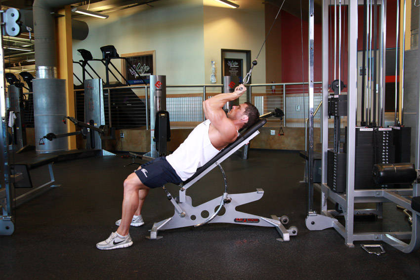 Demonstration of Cable Incline Triceps Extension exercise showing proper form and technique