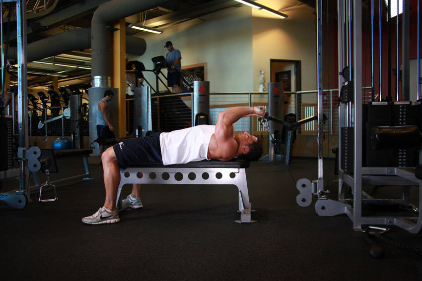 Demonstration of Cable Lying Triceps Extension exercise showing proper form and technique