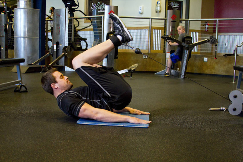 Demonstration of Cable Reverse Crunch exercise showing proper form and technique