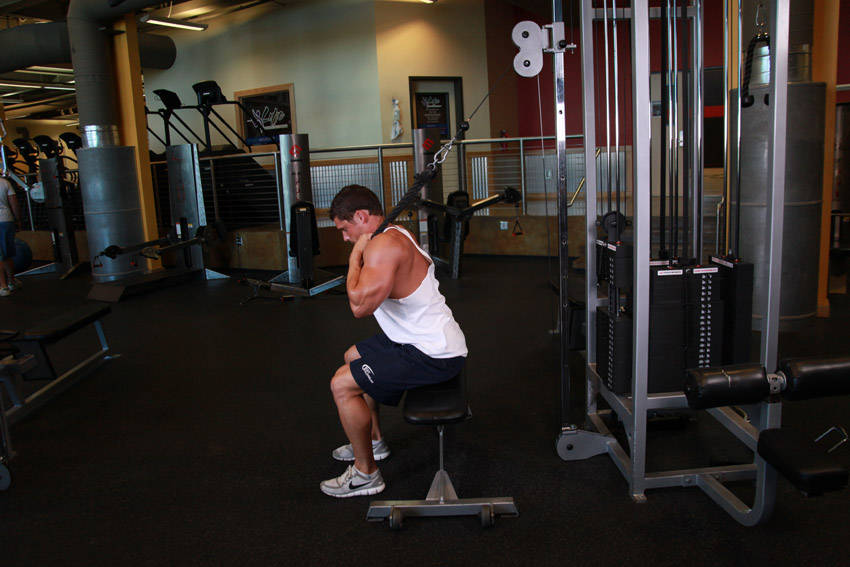 Demonstration of Cable Seated Crunch exercise showing proper form and technique