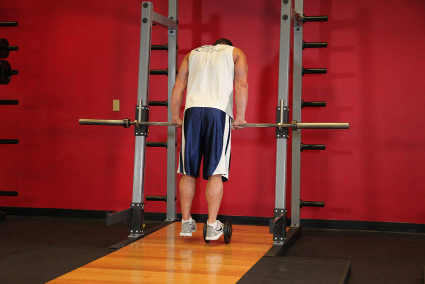 Demonstration of Calf Raise On A Dumbbell exercise showing proper form and technique