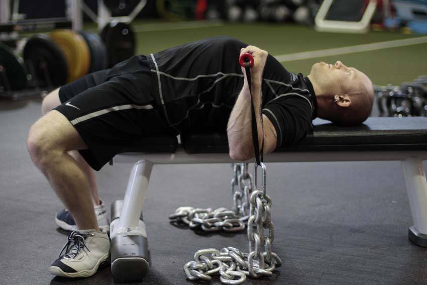 Demonstration of Chain Press exercise showing proper form and technique