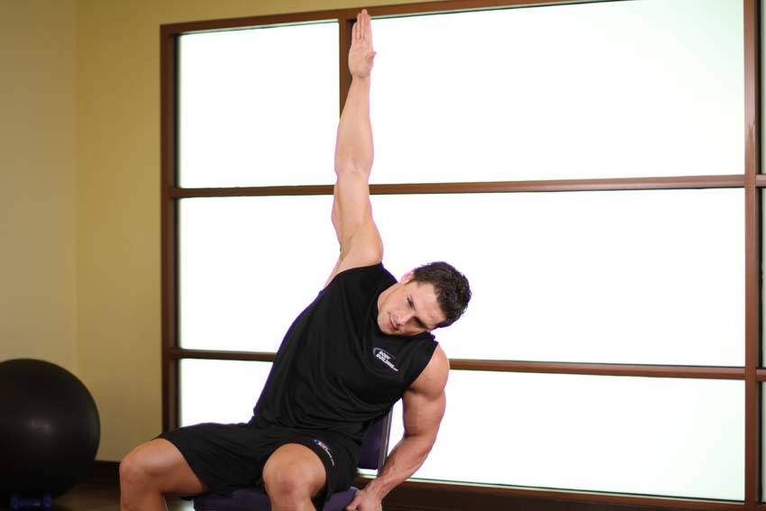 Demonstration of Chair Lower Back Stretch exercise showing proper form and technique