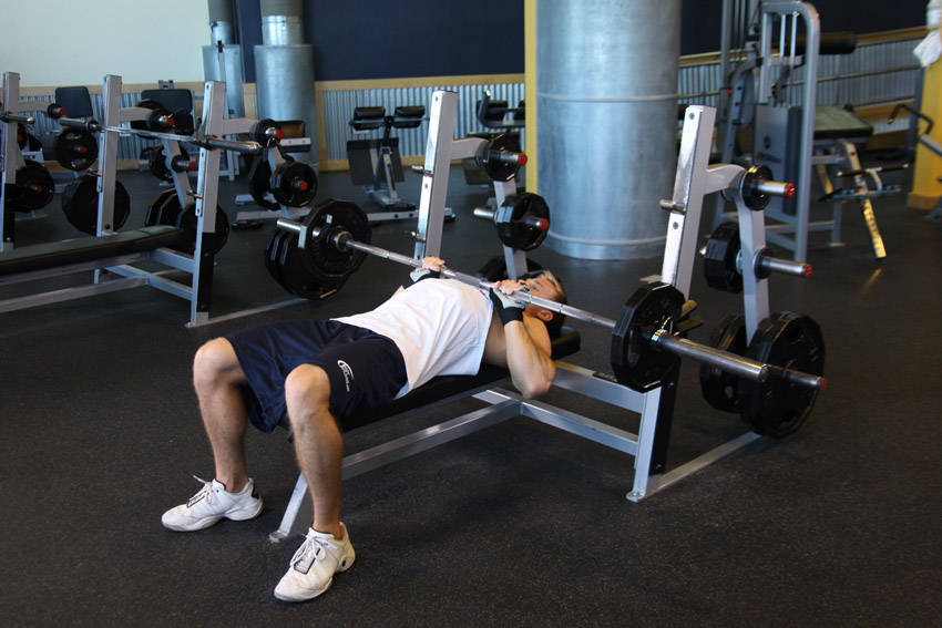 Demonstration of Close-Grip Barbell Bench Press exercise showing proper form and technique