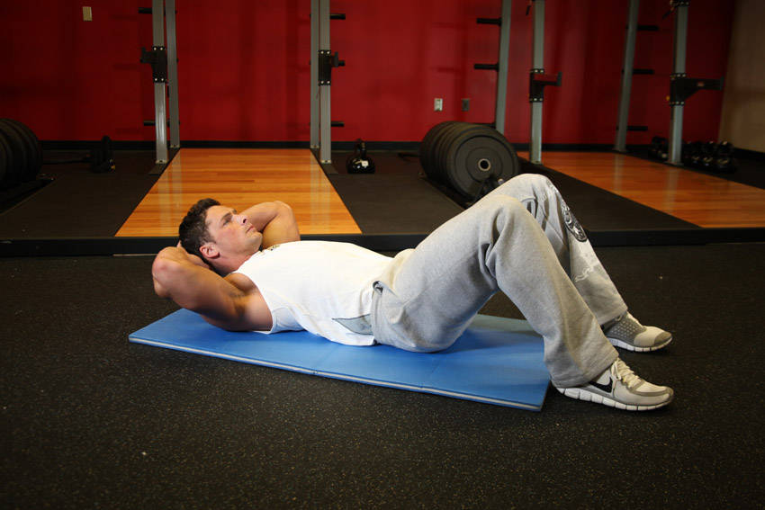Demonstration of Cross-Body Crunch exercise showing proper form and technique