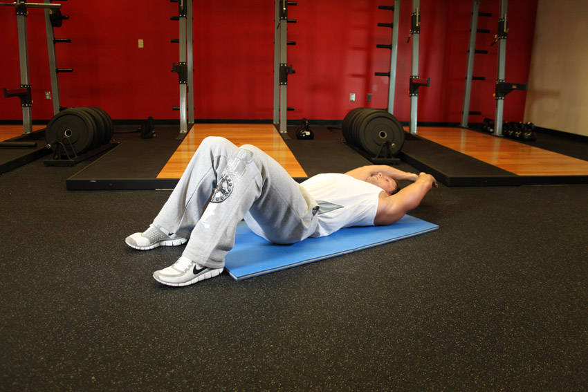 Demonstration of Crunch - Hands Overhead exercise showing proper form and technique