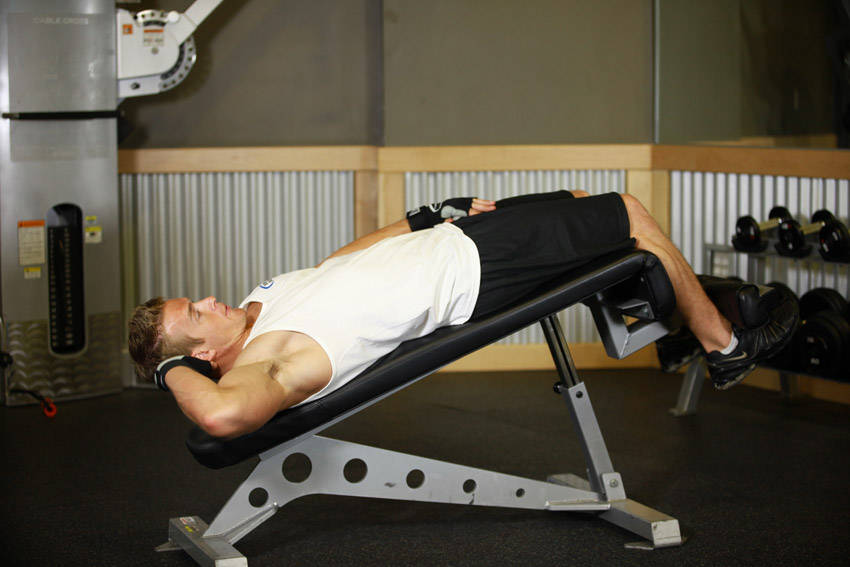 Demonstration of Decline Oblique Crunch exercise showing proper form and technique