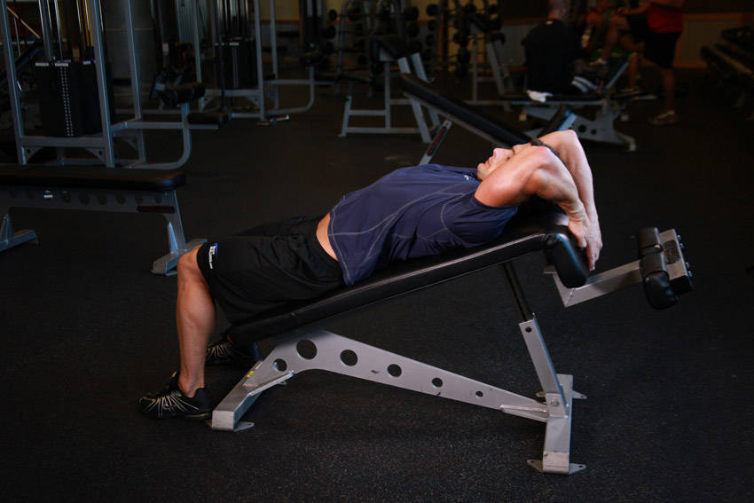 Demonstration of Decline Reverse Crunch exercise showing proper form and technique