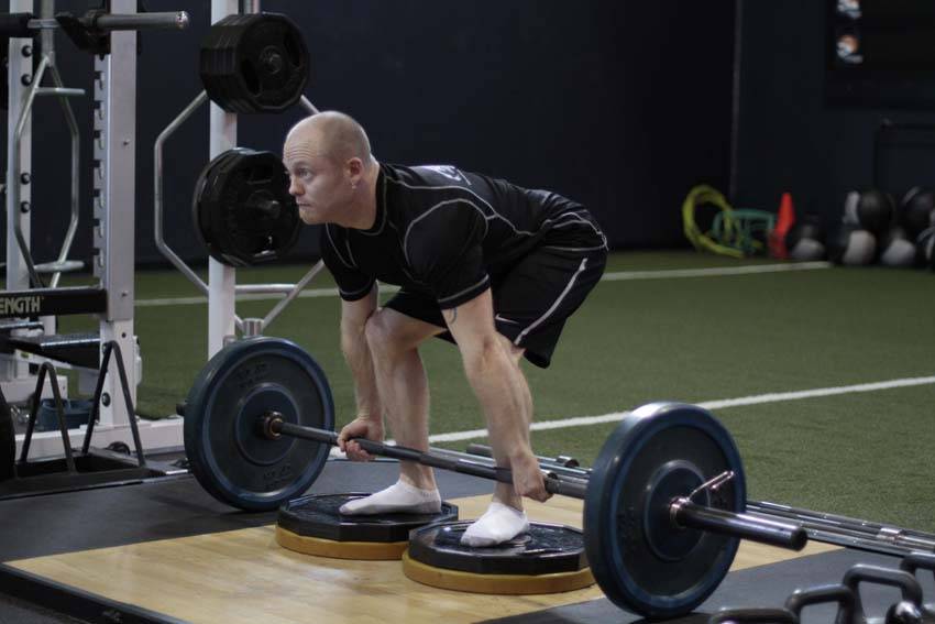 Demonstration of Deficit Deadlift exercise showing proper form and technique
