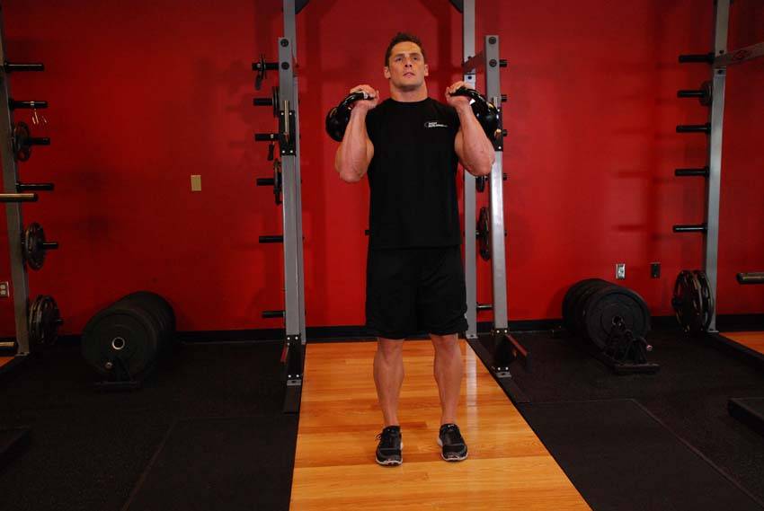 Demonstration of Double Kettlebell Jerk exercise showing proper form and technique