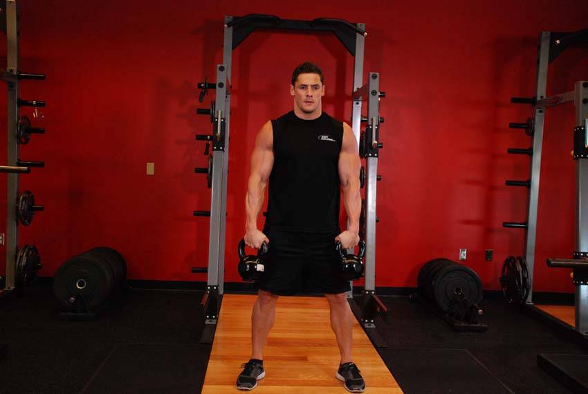 Demonstration of Double Kettlebell Snatch exercise showing proper form and technique
