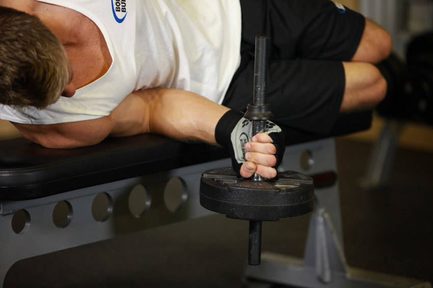 Demonstration of Dumbbell Lying Pronation exercise showing proper form and technique