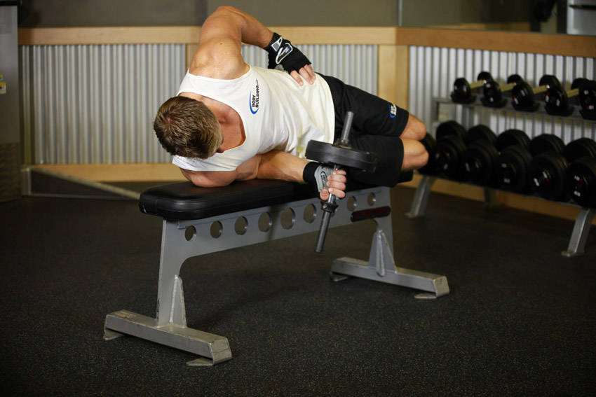Demonstration of Dumbbell Lying Supination exercise showing proper form and technique