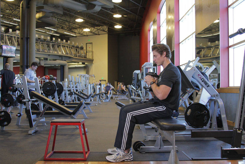 Demonstration of Dumbbell Seated Box Jump exercise showing proper form and technique