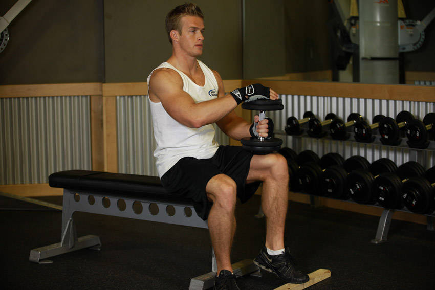 Demonstration of Dumbbell Seated One-Leg Calf Raise exercise showing proper form and technique