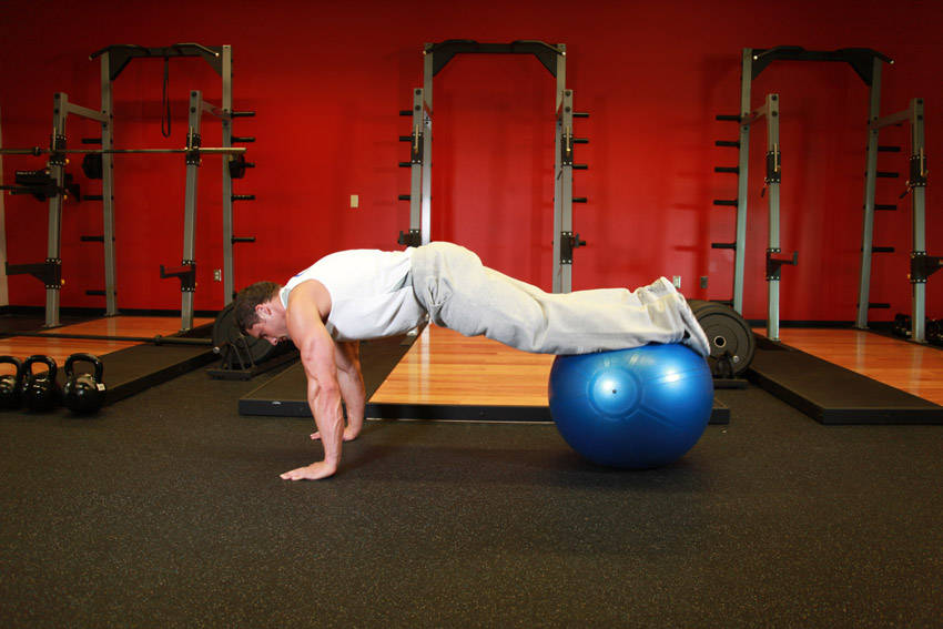 Demonstration of Exercise Ball Pull-In exercise showing proper form and technique