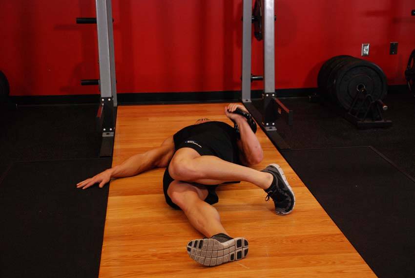 Demonstration of Extended Range One-Arm Kettlebell Floor Press exercise showing proper form and technique
