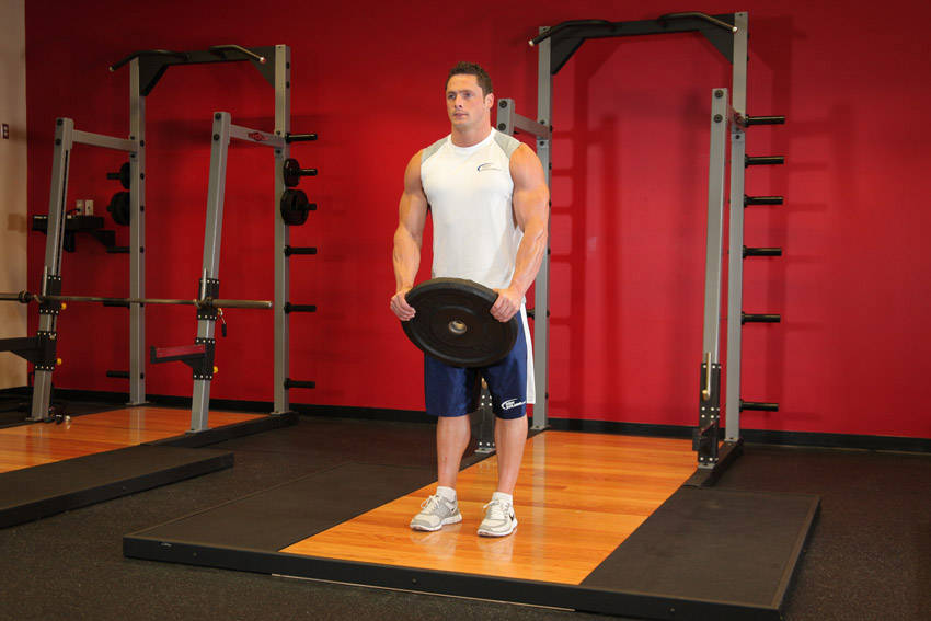 Demonstration of Front Plate Raise exercise showing proper form and technique