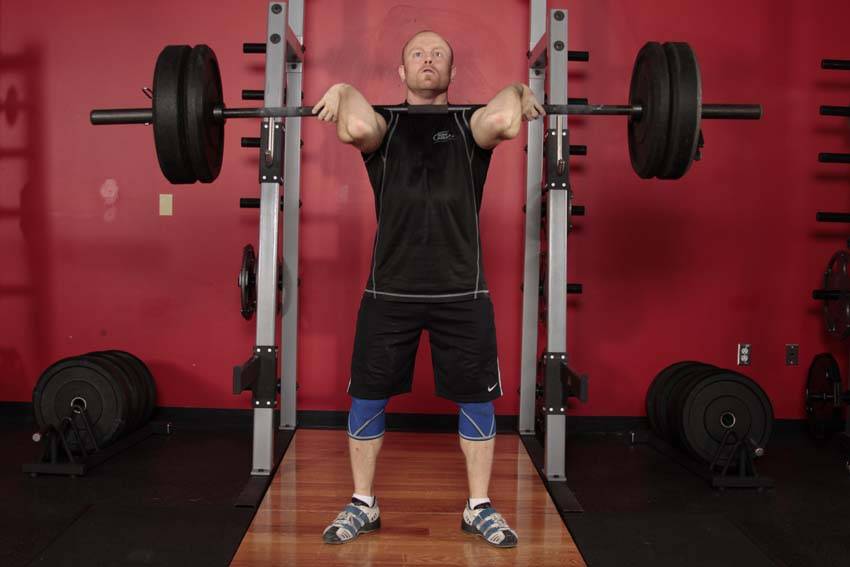 Demonstration of Front Squat (Clean Grip) exercise showing proper form and technique