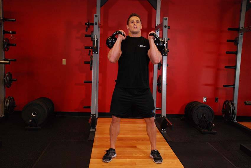 Demonstration of Front Squats With Two Kettlebells exercise showing proper form and technique