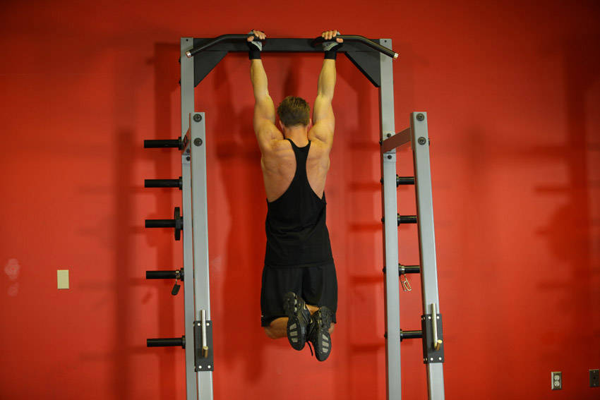 Demonstration of Gorilla Chin/Crunch exercise showing proper form and technique