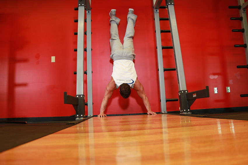 Demonstration of Handstand Push-Ups exercise showing proper form and technique