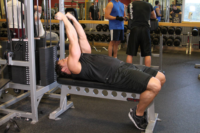 Demonstration of High Cable Curls exercise showing proper form and technique