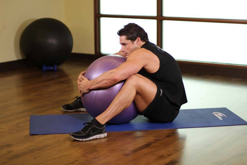Demonstration of Hug A Ball exercise showing proper form and technique