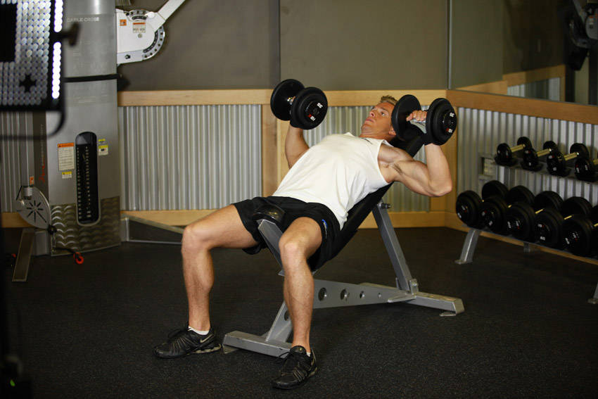 Demonstration of Incline Dumbbell Press exercise showing proper form and technique