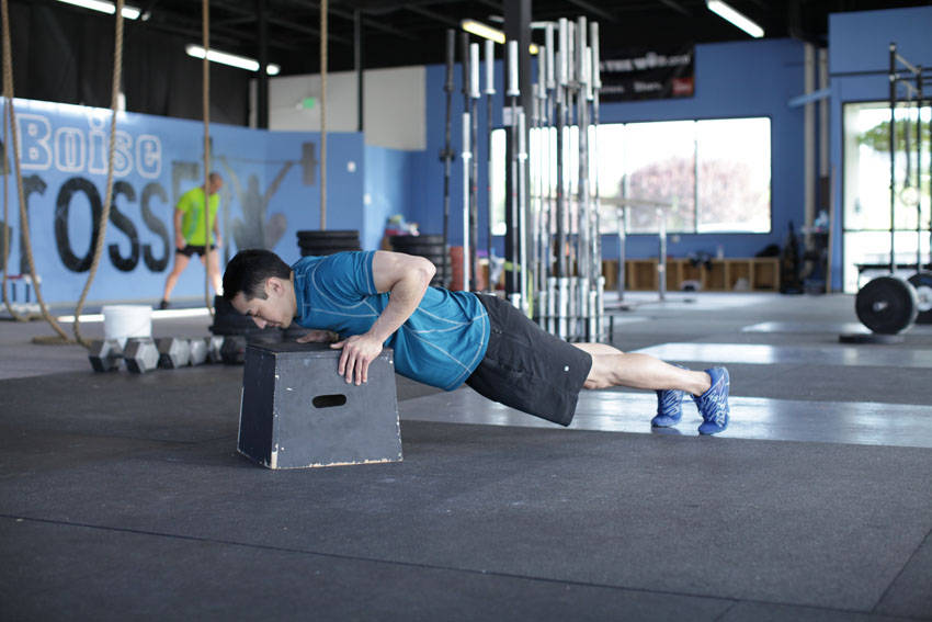 Demonstration of Incline Push-Up exercise showing proper form and technique