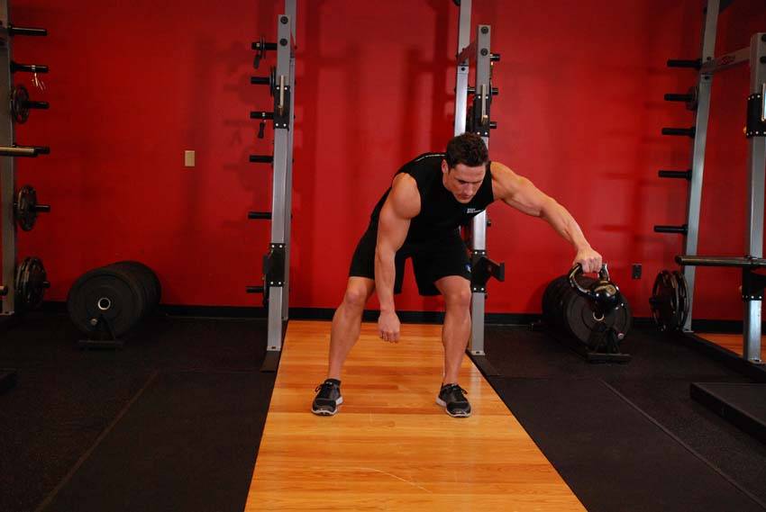 Demonstration of Kettlebell Pass Between The Legs exercise showing proper form and technique