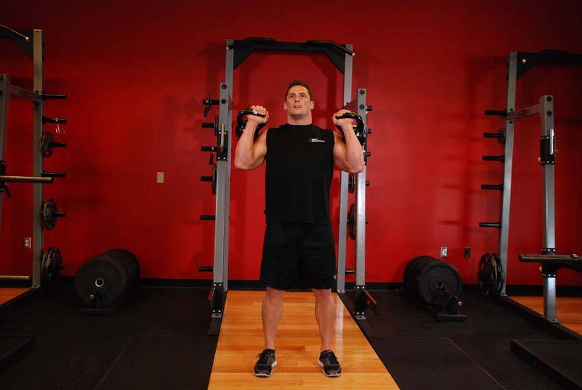Demonstration of Kettlebell Seesaw Press exercise showing proper form and technique