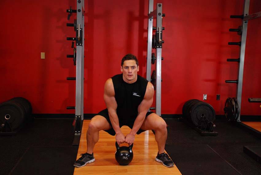 Demonstration of Kettlebell Sumo High Pull exercise showing proper form and technique