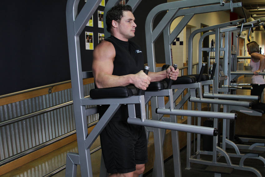 Demonstration of Knee/Hip Raise On Parallel Bars exercise showing proper form and technique