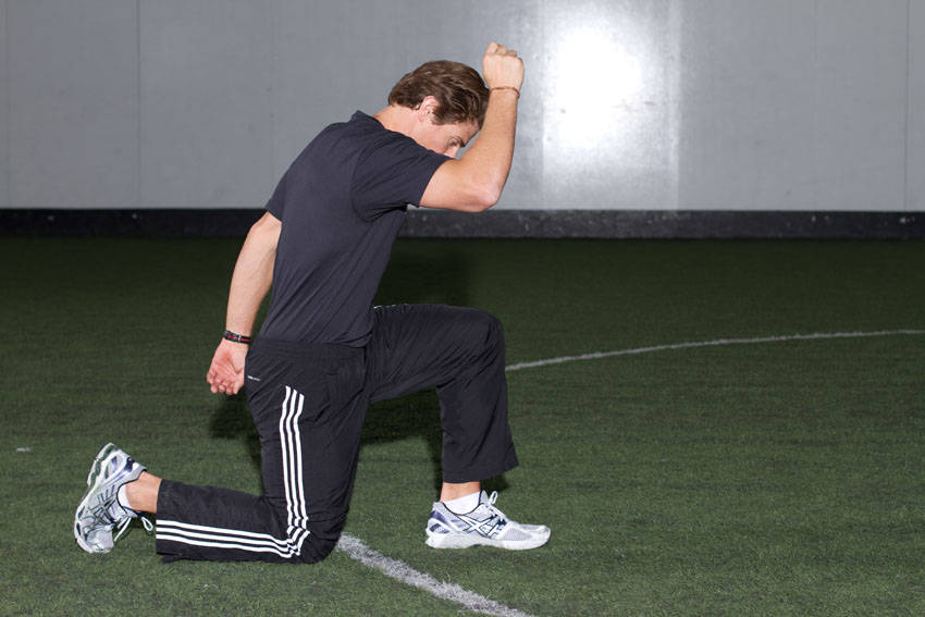 Demonstration of Kneeling Arm Drill exercise showing proper form and technique