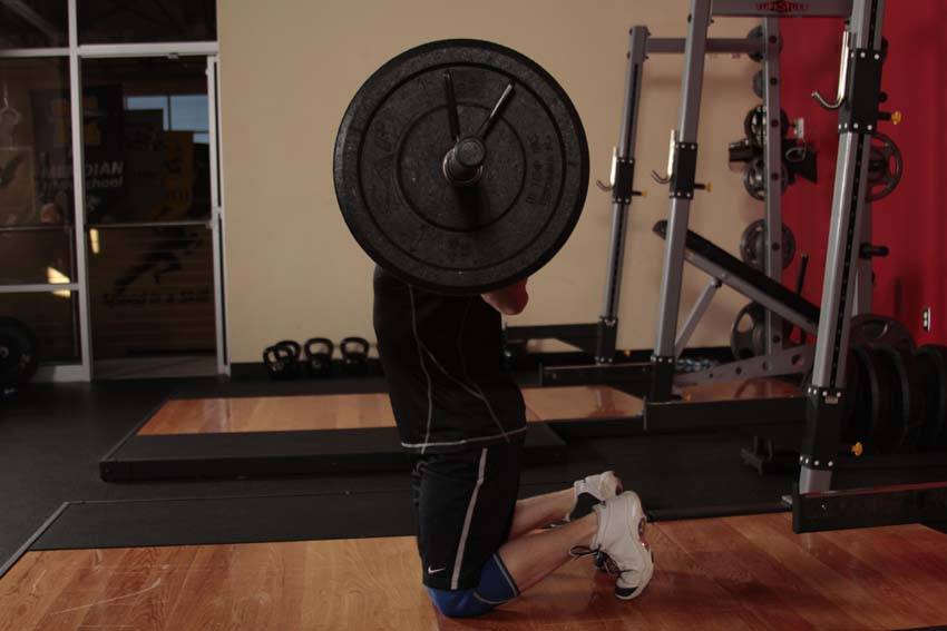 Demonstration of Kneeling Jump Squat exercise showing proper form and technique