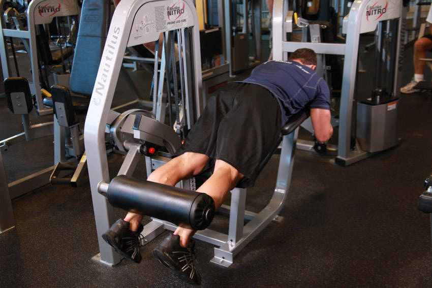 Demonstration of Lying Leg Curls exercise showing proper form and technique