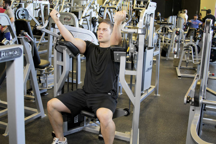 Demonstration of Machine Bicep Curl exercise showing proper form and technique